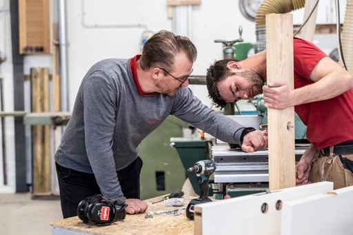 2 tømrere arbejder med træ